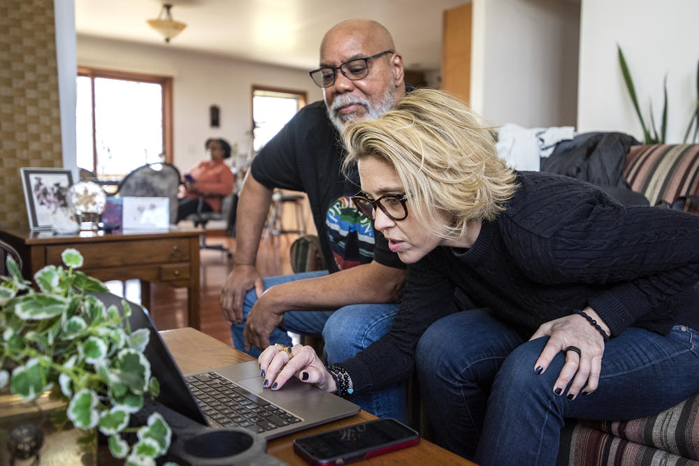 Peter Baker, left, and Katie Green, right, look at photos of Lake Ivanhoe at Peter's home in the area.