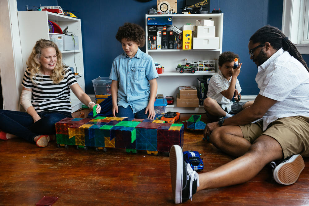 Allyson Ward and her husband, Marcus Ward, play with their twin sons, Milo and Theo, both 10. The family's debt reached $80,000 following years of care for the boys.