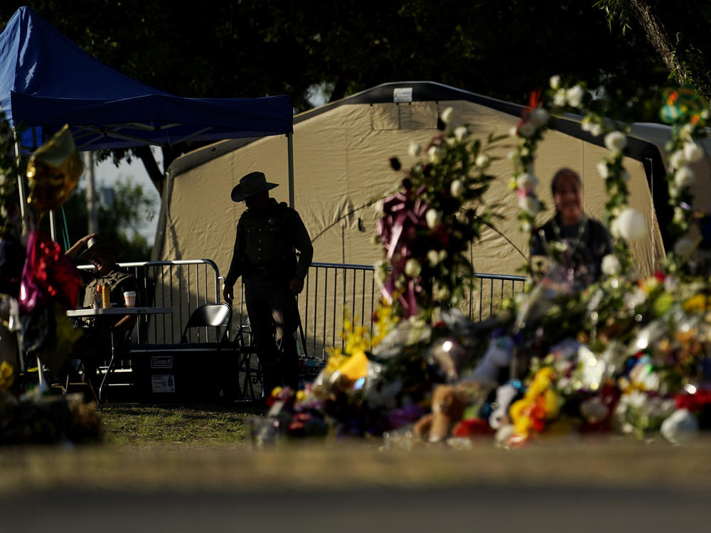 A Texas Department of Public Safety officer keeps watch on June 3, 2022, in Uvalde, Texas, near a memorial outside Robb Elementary School.