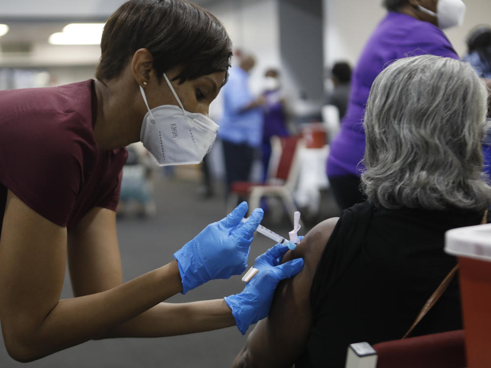 A Black woman receives a COVID-19 vaccine at a clinic in Tampa, Fla. Black Americans have died of the disease at a rate more than double that of white people.