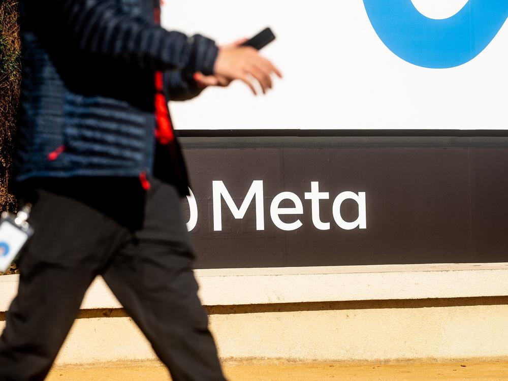 A person walks past a sign bearing Meta's logo at the company's Menlo Park headquarters in October 2021. The company is introducing new safety measures for younger Instagram users after facing widespread scrutiny.