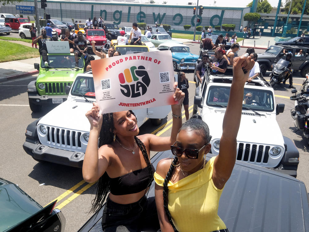 Jasmine Kingi, left, 26, and Robin Renee Green, 26, both from Los Angeles, celebrate as they take part in a car parade to mark Juneteenth, on June 19, 2021 in Inglewood, Calif.