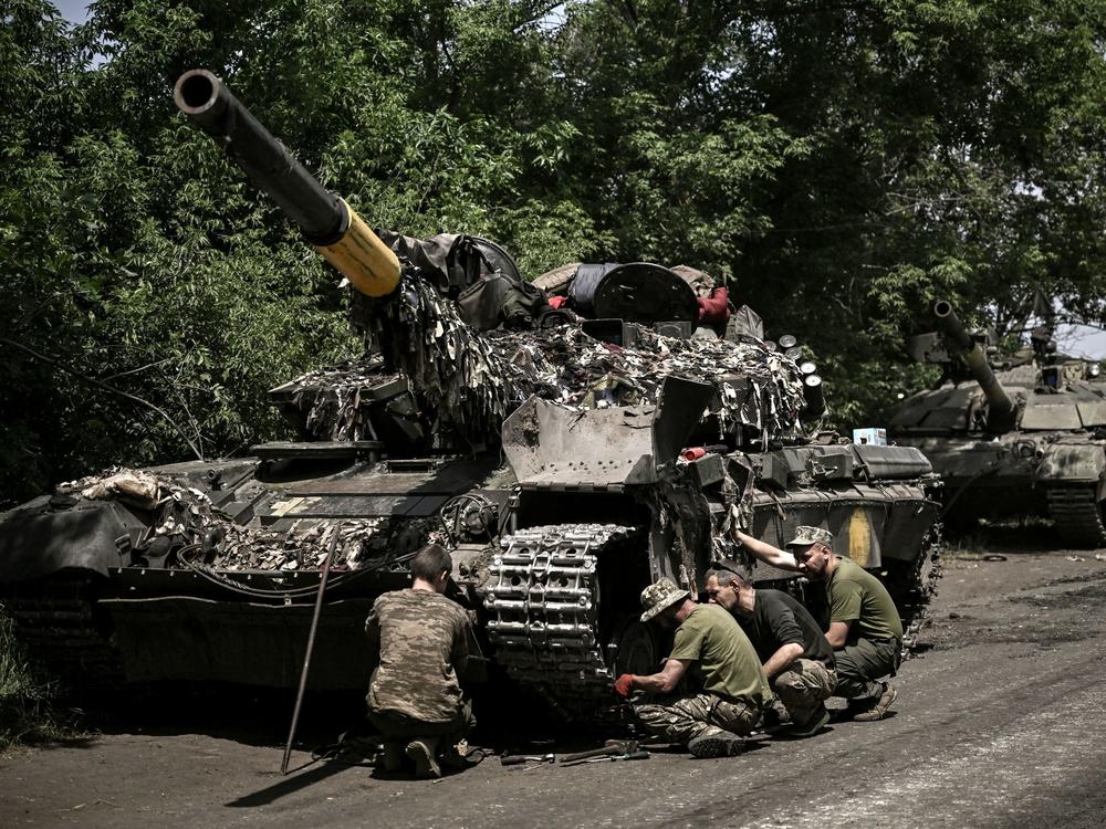 Ukrainian troops repair an army tank in Ukraine's eastern Donbas region on June 7. Ukrainians have been urging the U.S. and its allies to supply them more weapons in their fight against Russia, and Gen. Mark Milley, President Biden's top military adviser, told NPR that Russia has massed greater numbers of combat units, as well as more artillery, than the local defenders in the Donbas have.