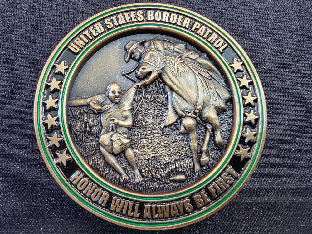 The challenge coin depicts the photo of last year's incident in which a Border Patrol agent on horseback grabbed a Haitian migrant by the shirt.