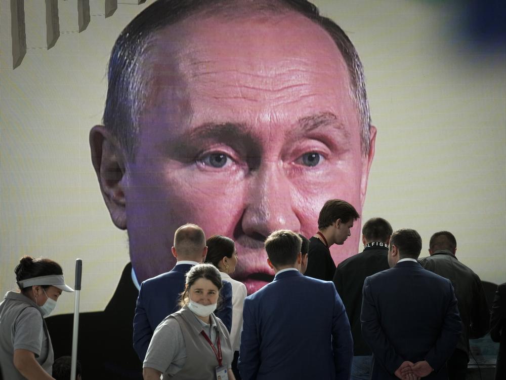 Participants watch Russian President Vladimir Putin address the St. Petersburg International Economic Forum in St. Petersburg, Russia, on Friday.
