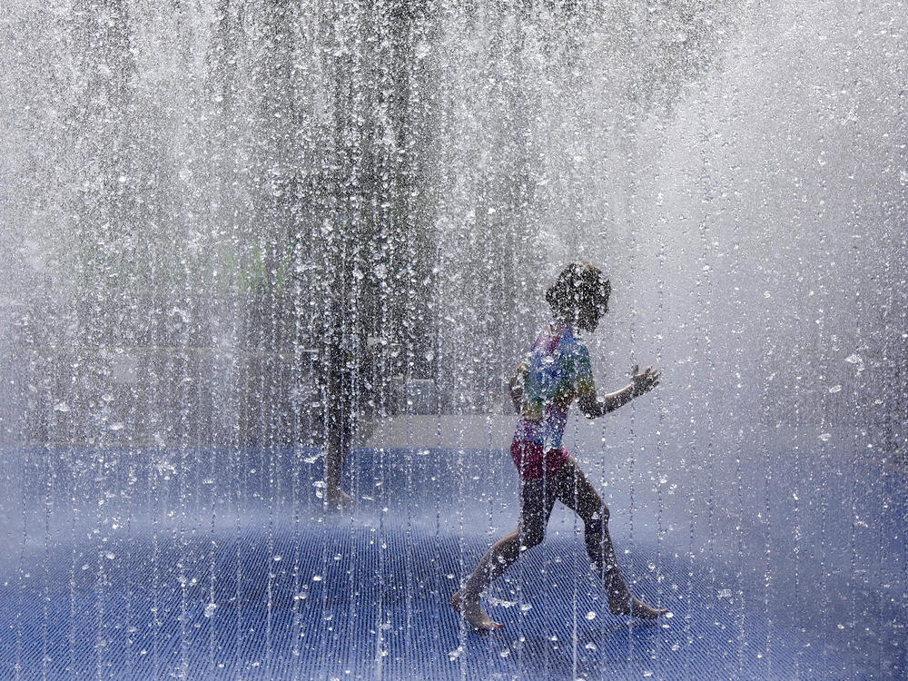 A child plays in a fountain in the warm weather in London, Friday, June 17, 2022. A blanket of hot air stretching from the Mediterranean to the North Sea is giving much of western Europe its first heat wave of the summer, with temperatures forecast to top 30 degrees Celsius (86 degrees Fahrenheit) from Malaga to London on Friday.