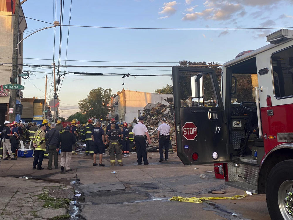 Emergency personnel respond to the scene of a building that caught fire then collapsed early Saturday in Philadelphia. The Philadelphia Fire Department said several firefighters and a city inspector became trapped when the building collapsed.
