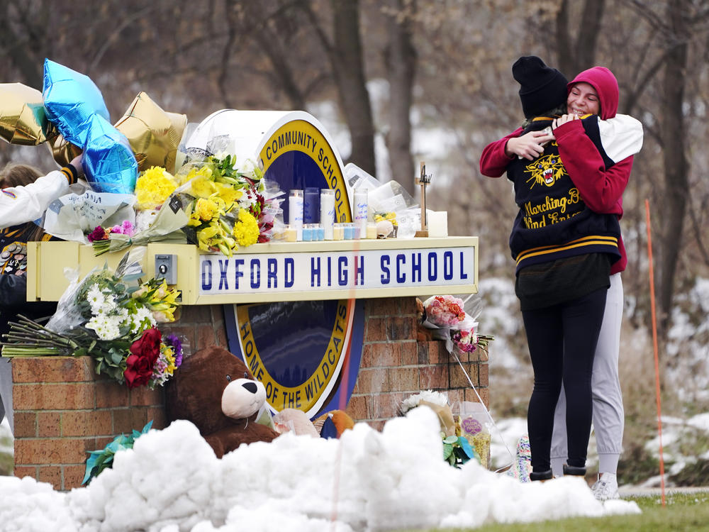 Students hug at a memorial at Oxford High School in Oxford, Mich., Dec. 1, 2021.