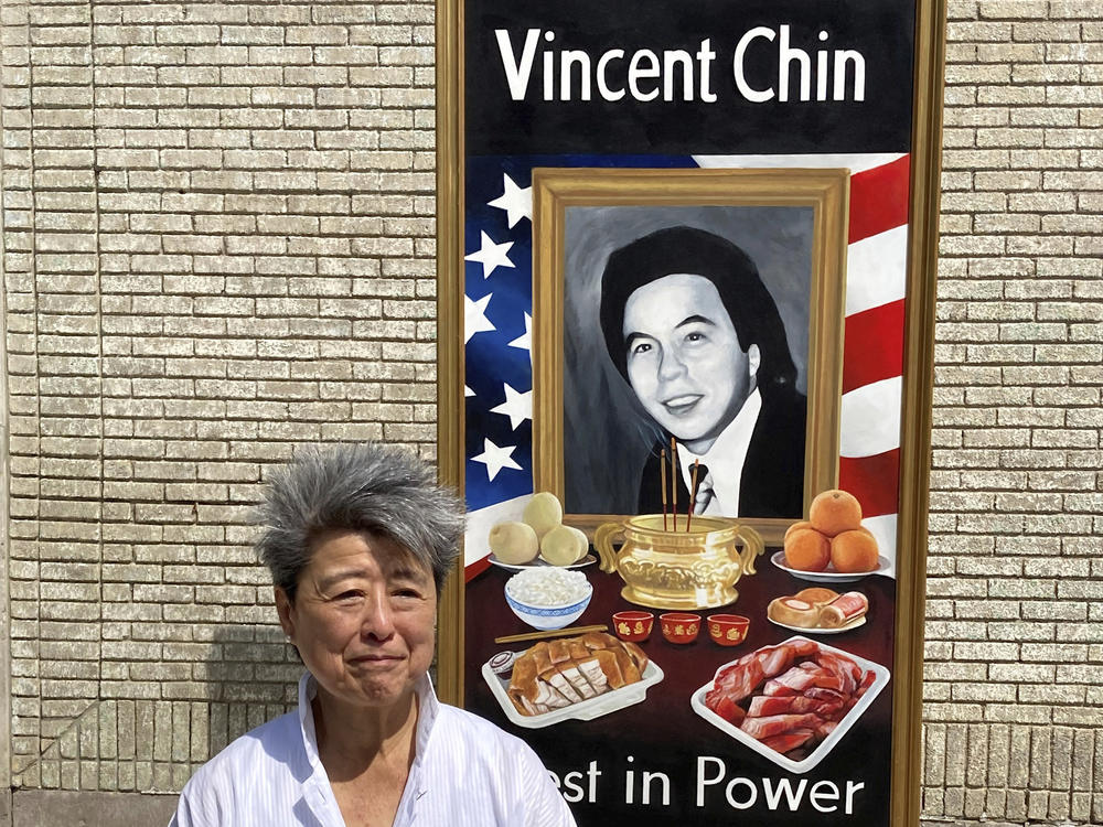 Activist and author Helen Zia stands next to a painting of Vincent Chin in Detroit. The city is partnering with The Vincent Chin 40th Remembrance & Rededication Coalition to honor civil rights efforts that began with Chin's killing in 1982.