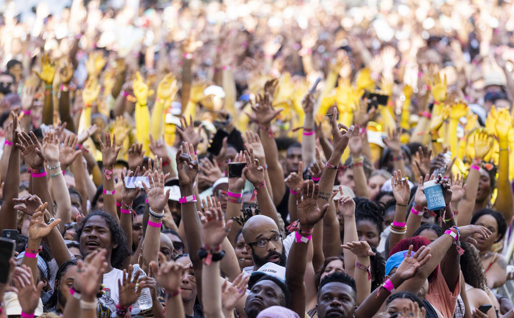 The crowds raise their hands during 6lack performance.