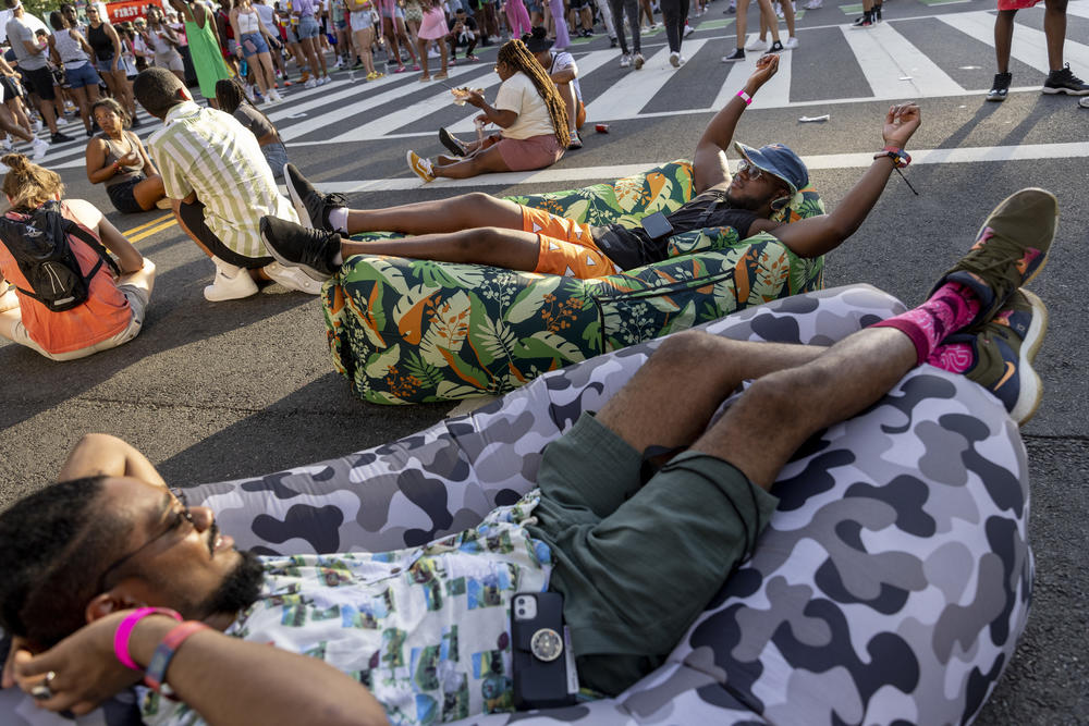 Friends Ibrahim Hydara, from Rockville, MD (center with hat) and Rasheed Billy from Baltimore, MD in their inflatable couches as they enjoy the scene at the music festivalon Fri., June 17.