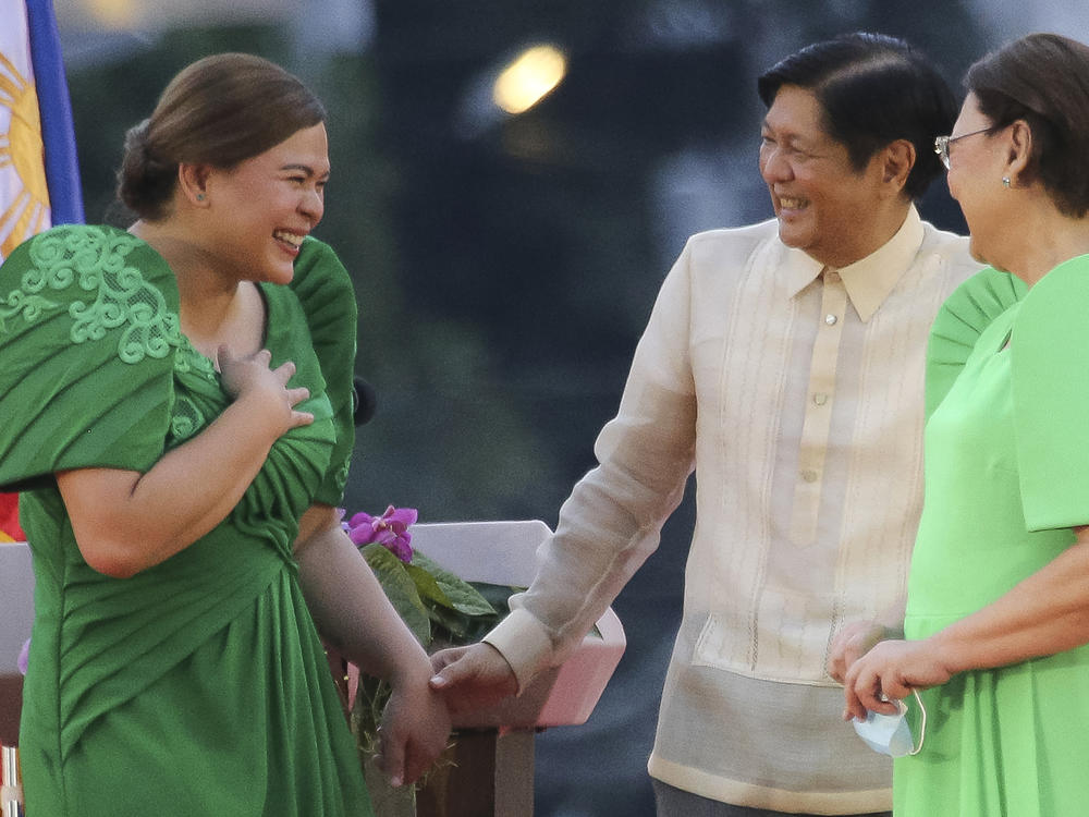 Philippine Vice President-elect Sara Duterte, left, is greeted by incoming Philippine President Ferdinand 