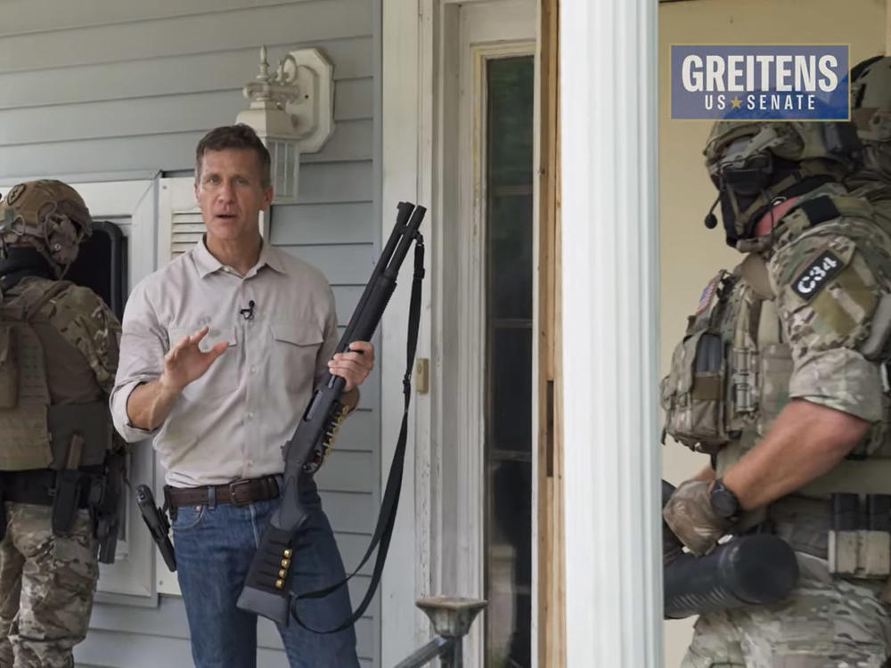 In a new campaign ad, Eric Greitens carries a shotgun and stands alongside men in military gear as they break into a home.