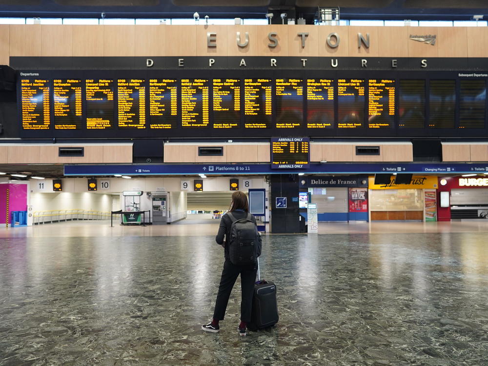 A passenger at Euston station in London looks at the departures board on the first day of a rail strike on Tuesday June 21, 2022.