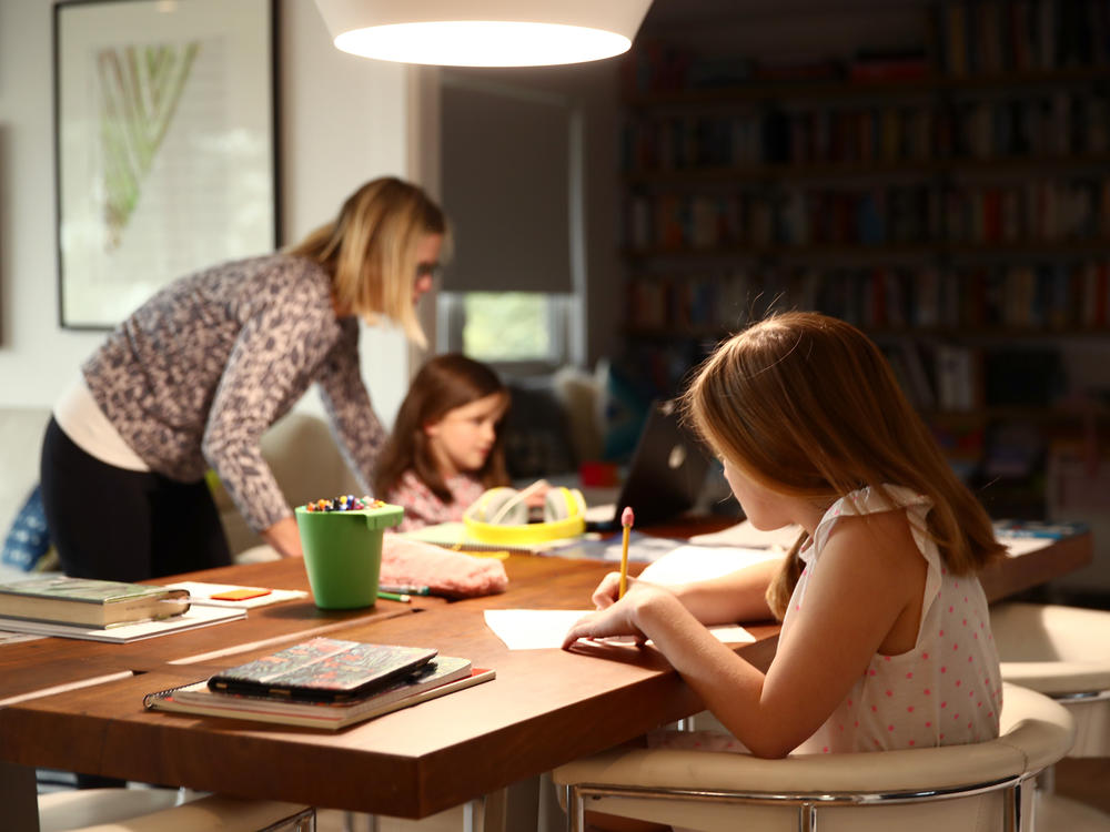 Fourth-grader Lucy Kramer (foreground) does schoolwork at her home, as her mother, Daisley, helps her younger sister, Meg, who is in kindergarten, in 2020 in San Anselmo, Calif.