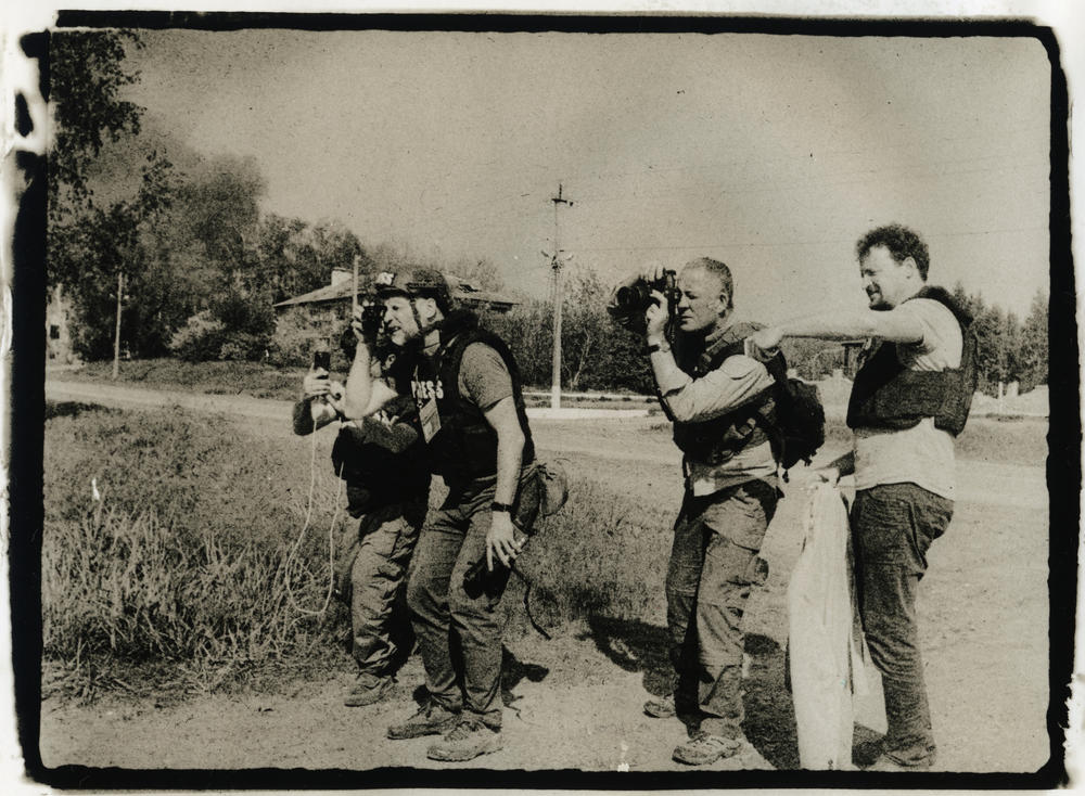 Journalists document the war in Tsyrkuny, a village on the outskirts of Kharkiv, Ukraine, in May.