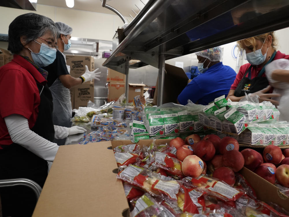Los Angeles Unified School District food service workers  pre-package hundreds of free school lunches in plastic bags.