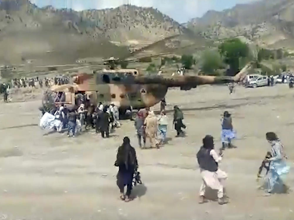 In this image taken from video from Bakhtar State News Agency, Taliban fighters secure a government helicopter to evacuate injured people in Gayan district, Paktika province, Afghanistan, Wednesday, June 22, 2022.