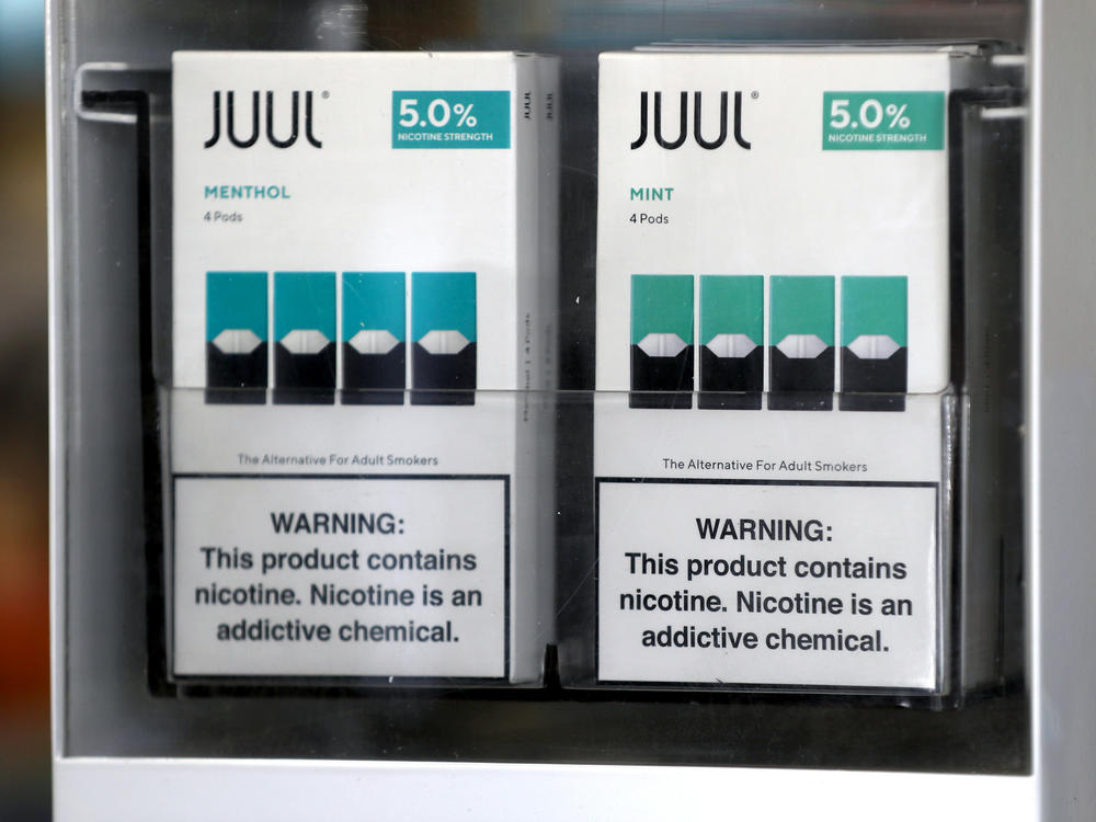 Packages of Juul mint-flavored e-cigarettes are displayed at a smoke shop in 2019.