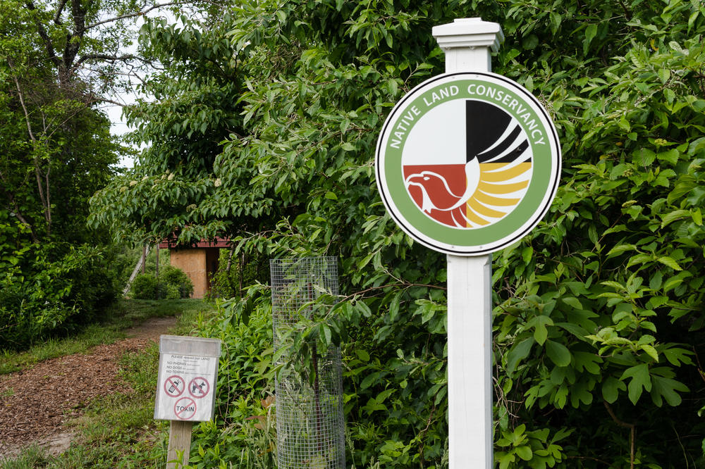 A Native Land Conservancy sign is located at the entrance of Sassafras Earth Education.