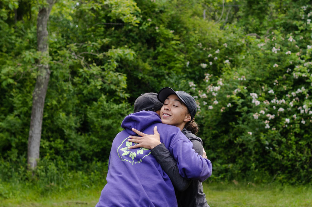 David Vanderhoop, hugs Tysonnae Aiguier-Bolling, before an employee training at Sassafras Earth Education.