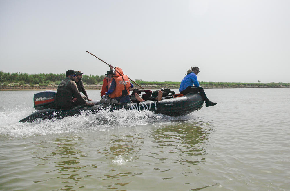 Members of the expedition rest in a rubber dinghy that they used to raft down the river.