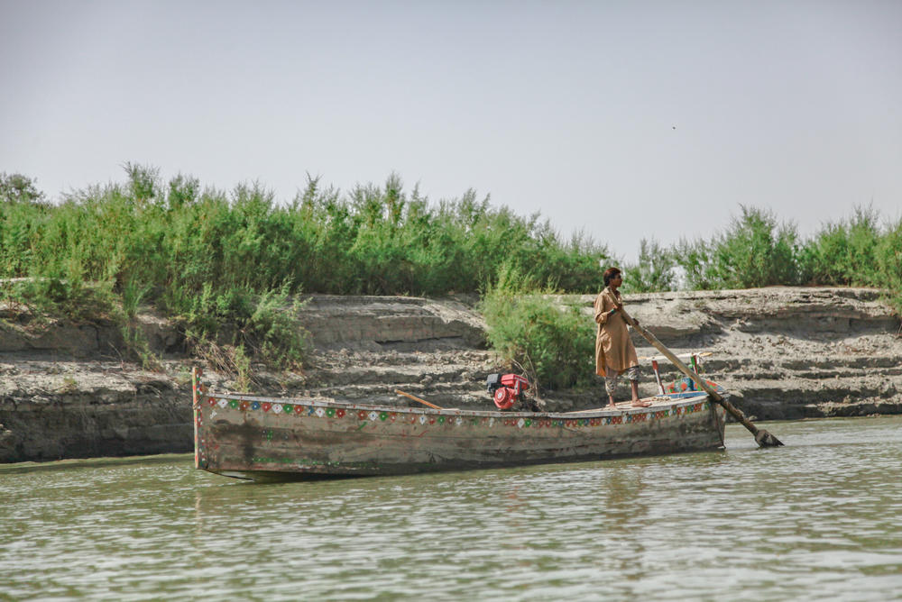 A fisherman stands on his boat on the lower stretch of the Indus River.