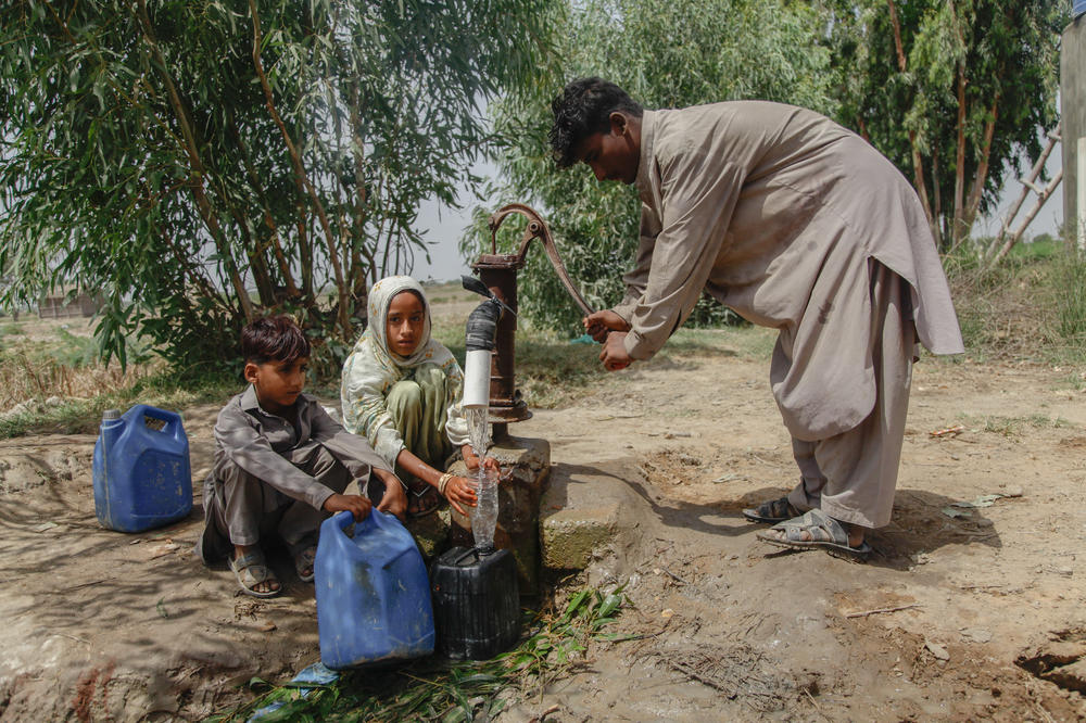 A man pumps brackish water from a well near parched lands at the tail end of the Indus River.