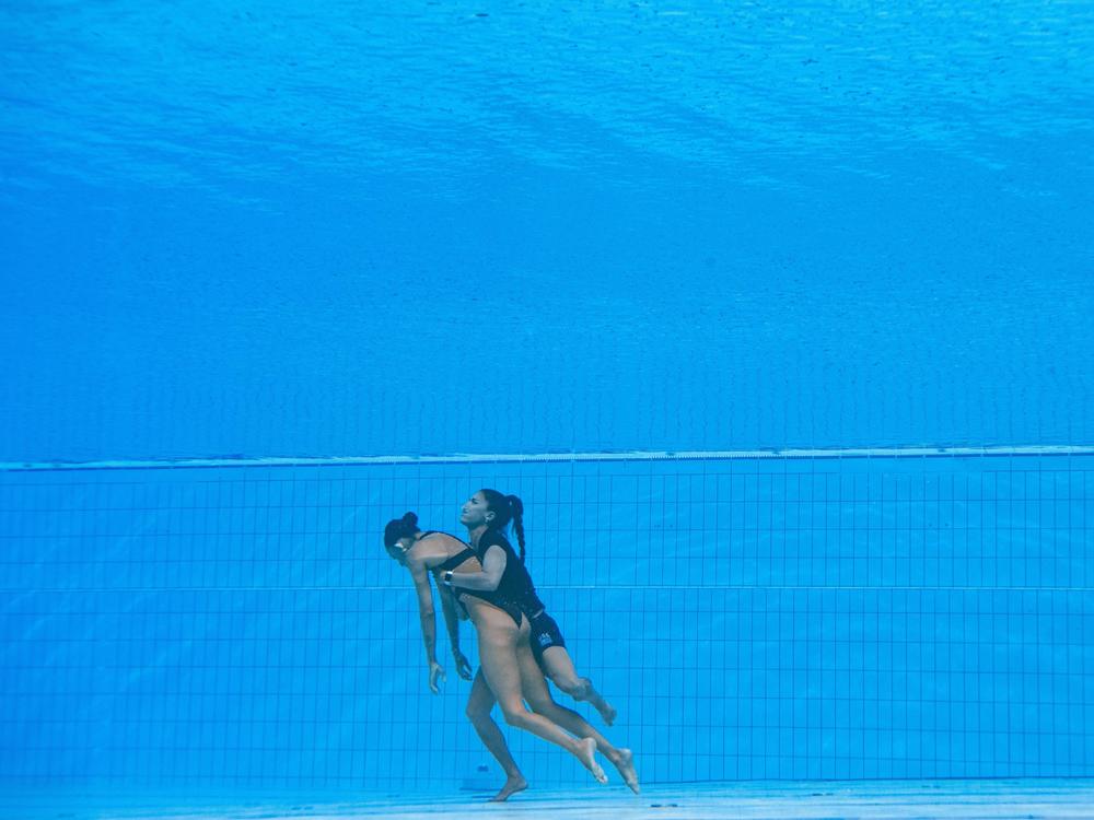 Team USA coach Andrea Fuentes brings Anita Alvarez from the bottom of the pool at the 2022 World Aquatics Championships in Budapest.