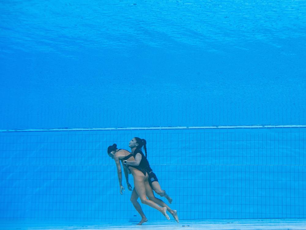 Team USA coach Andrea Fuentes brings Anita Alvarez from the bottom of the pool at the 2022 World Aquatics Championships in Budapest.