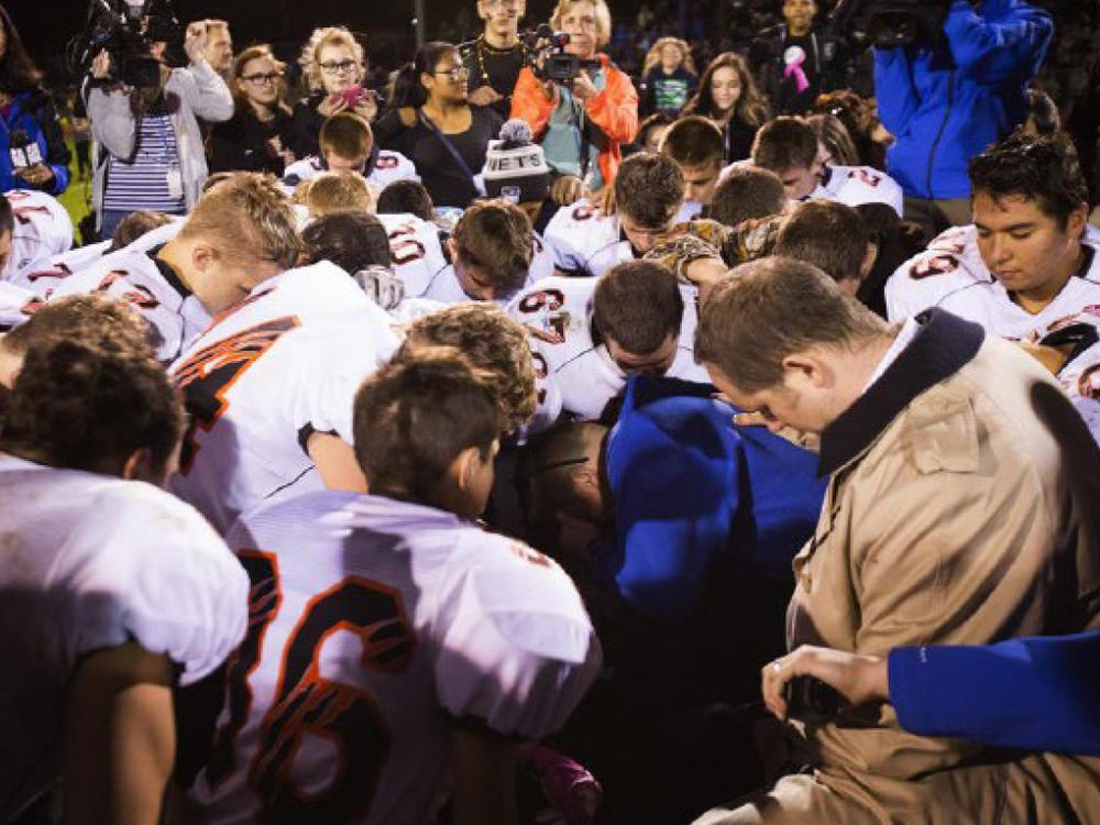 The parties included this image, of Coach Kennedy praying with a crowd after the homecoming game, in their joint appendix submitted to the Supreme Court