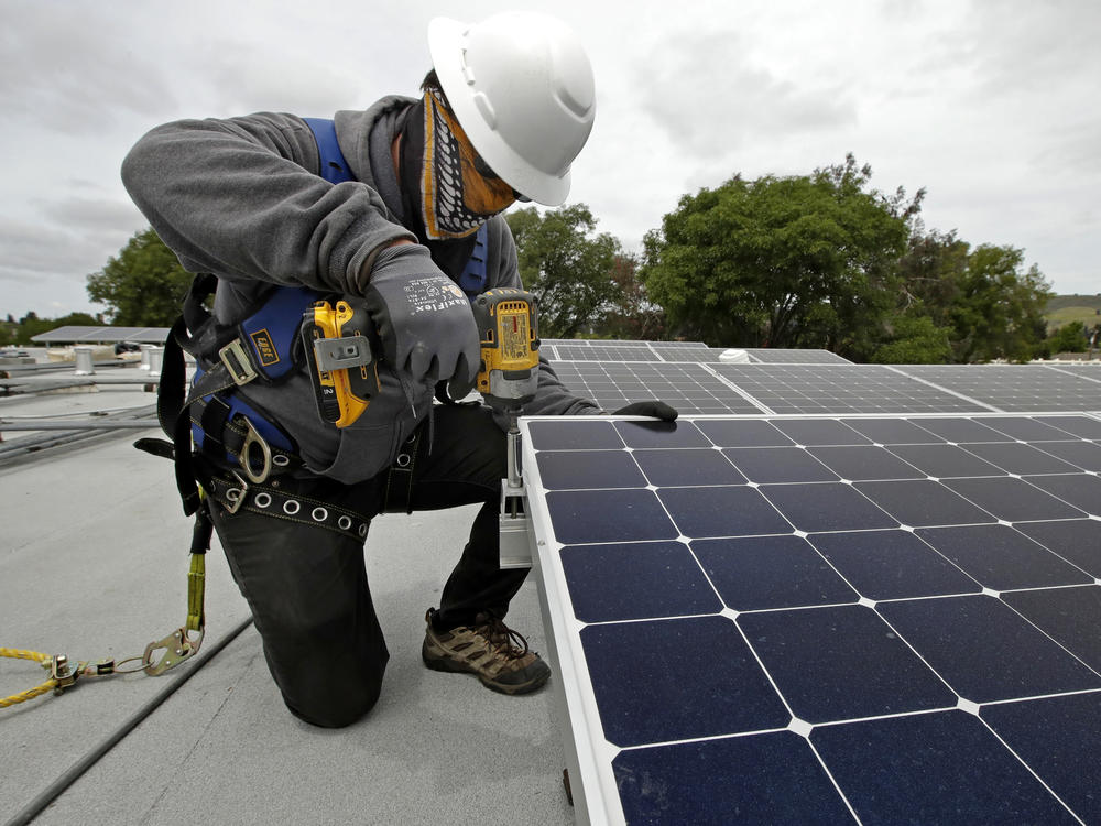 Gen Nashimoto, of Luminalt, installs solar panels in Hayward, Calif., on Wednesday, April 29, 2020.