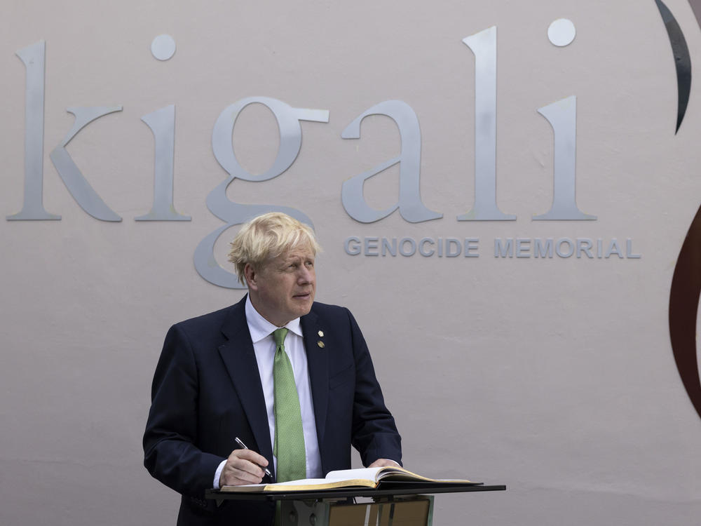 British Prime Minister Boris Johnson signs the visitors book while visiting the Kigali Genocide Memorial in Kigali, Rwanda, Thursday June 23, 2022.