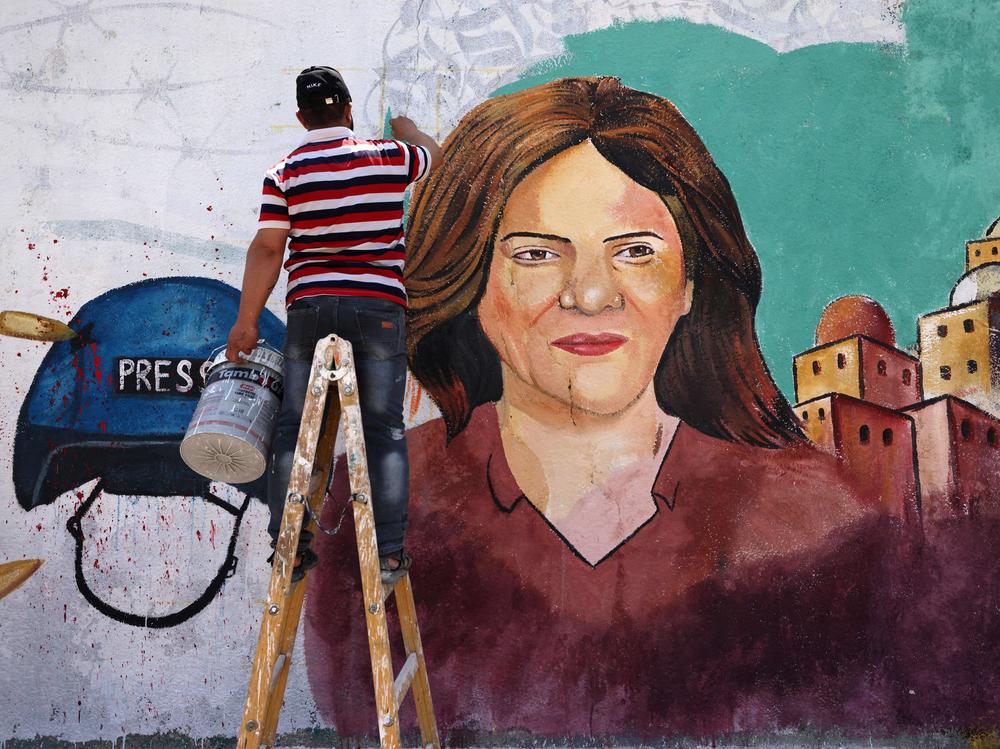 Palestinian artists paint a mural in honor of slain veteran Al Jazeera journalist Shireen Abu Akleh in Gaza City, after she was killed on May 11. A new U.N. report says Israeli forces fired the shots that killed Abu Akleh and injured a colleague.