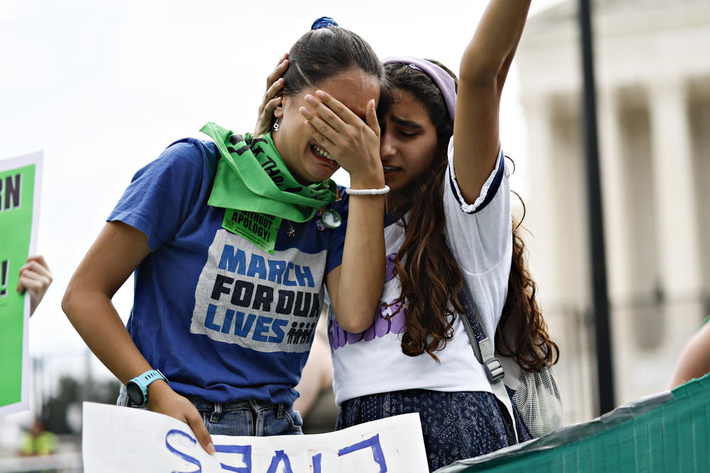Abortion rights demonstrators react outside the Supreme Court.