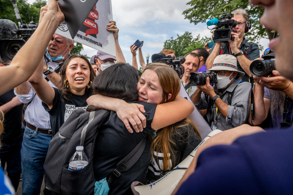 Anti-abortion activists react to the ruling in front of the Supreme Court.