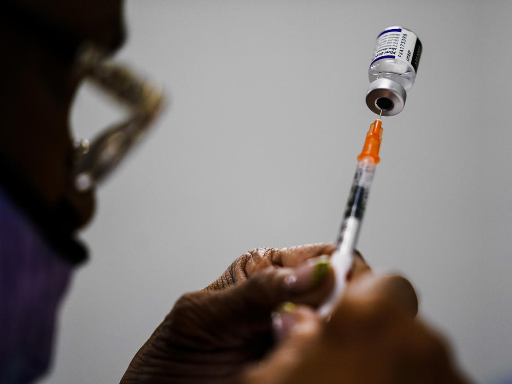 A syringe is prepared with the Pfizer COVID-19 vaccine at a vaccination clinic in Chester, Pa., on Dec. 15, 2021. Pfizer says tweaking its COVID-19 vaccine to better target the omicron variant is safe and boosts protection.