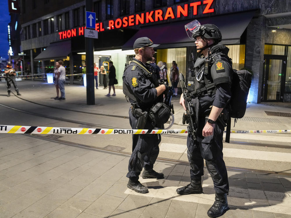 Police stand guard outside a bar in central Oslo, early Saturday. Norwegian police say two people have been killed and several injured in a mass shooting.