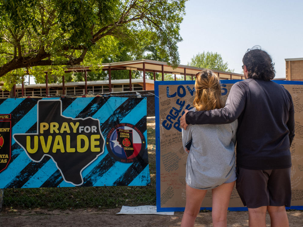 Siblings Kiley and Michael Regenthal pay their respects at a memorial in front of Robb Elementary School on June 17, in Uvalde, Texas.
