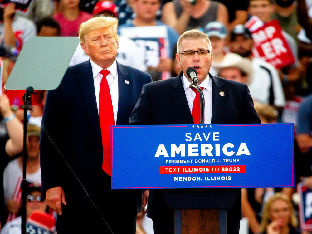 Darren Bailey, Illinois state Senator and Republican candidate for governor, speaks alongside former President Donald Trump on Saturday, June 25, 2022, during a rally at the Adams County Fairgrounds in Mendon, Ill. Trump has endorsed Bailey in the race.