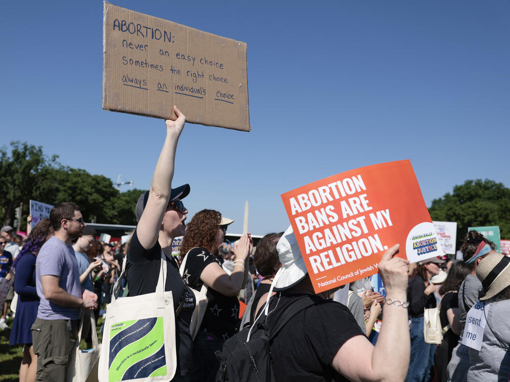 A protester carries a sign as they attend the 