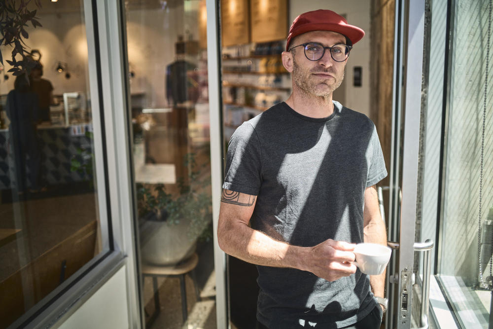 Scott Lucey stands in the entryway of Likewise in Milwaukee. Before opening the café in 2015, Lucey worked for 12 years as a barista and trainer for Alterra Coffee but always dreamed of having his own business.