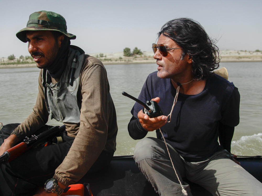 Wajahat Malik, right, and a Pakistan Navy seaman navigate the Indus River. Malik organized a 40-day expedition down the 2,000-mile river to document 