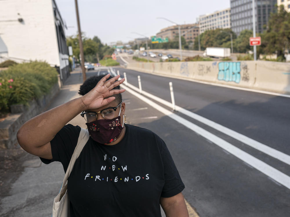 Katherine Morgan wipes sweat from her forehead while walking to work during a record-breaking heat wave in Portland in 2021. Scientists say that heat wave would have been virtually impossible without human caused climate change.
