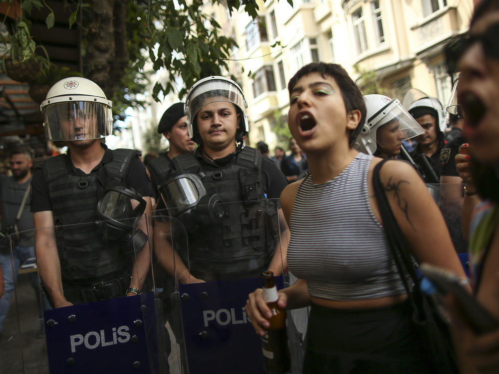 People shout slogans next to Turkish police officers during the LGBTQ Pride March in Istanbul, Turkey, Sunday, June 26, 2022.
