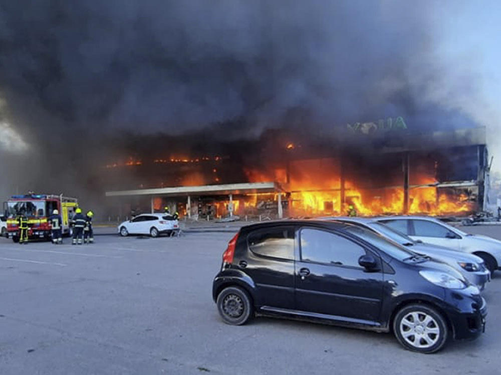 In this image made from video provided by Ukrainian State Emergency Service, firefighters work to extinguish a fire at a shopping center burned after a rocket attack in Kremenchuk, Ukraine, on Monday.