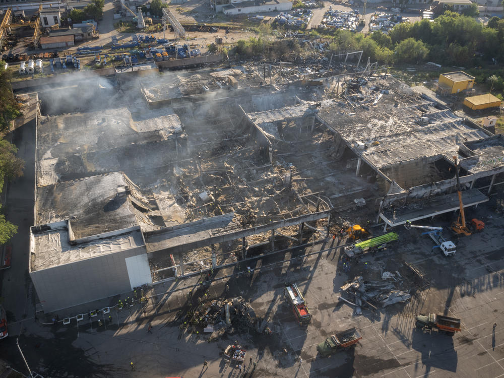 Ukrainian State Emergency Service firefighters work to take away debris at a shopping center burned after a rocket attack in Kremenchuk, Ukraine, Tuesday, June 28, 2022.