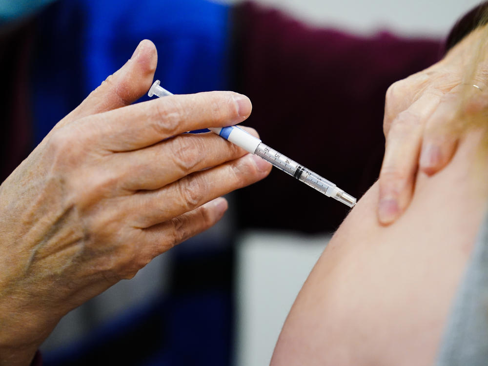 A health worker administers a dose of a COVID-19 vaccine during a vaccination clinic in Chester, Pa., on Dec. 15, 2021.