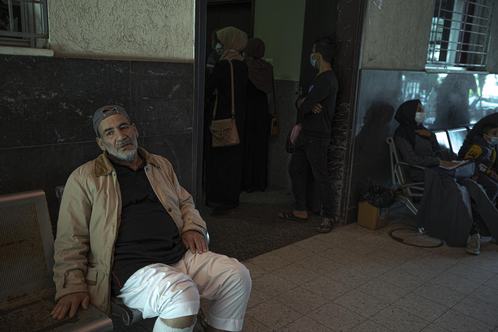 Yousef Al-Kurd, 70, a resident of Gaza with heart disease, waits to be seen by Dr. Saher Abu Ghali at Shifa Hospital. Al-Kurd is one of many Gazans who struggle to get permission to leave Gaza for medical treatment.