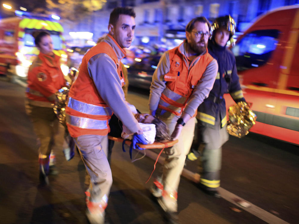 A woman is evacuated from the Bataclan concert hall in Paris after a shooting on Nov. 13, 2015.